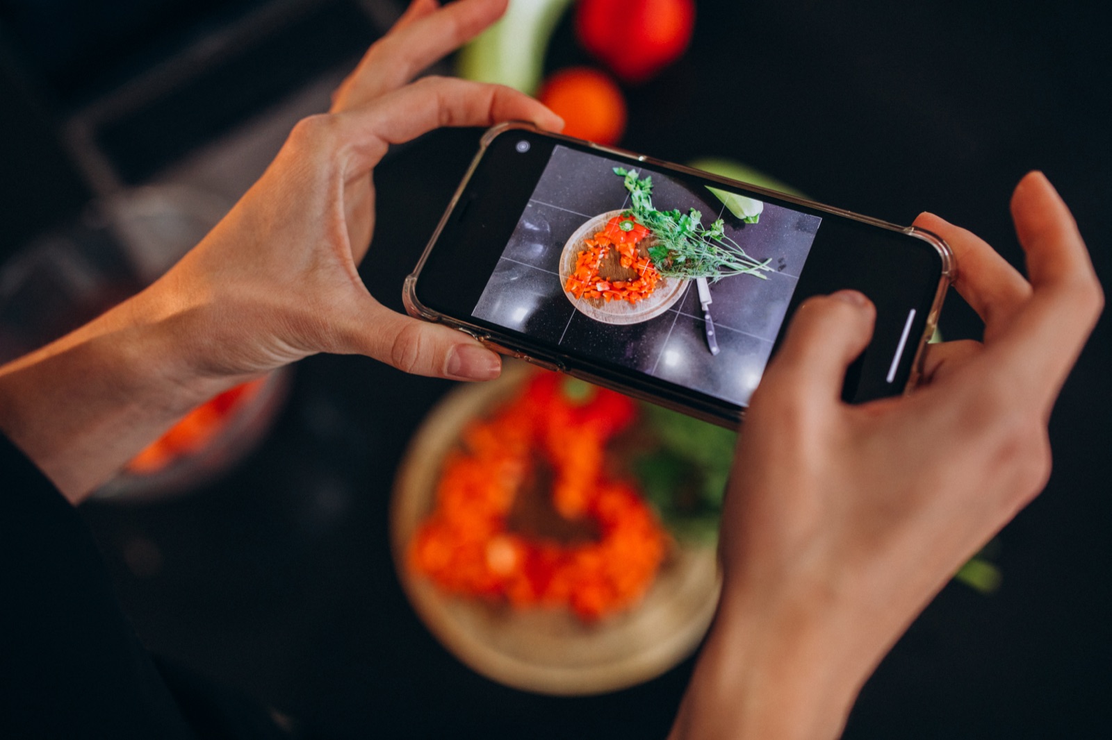Creator fotografando um prato com o celular para criar conteúdo de gastronomia, exemplo de formato de UGC.