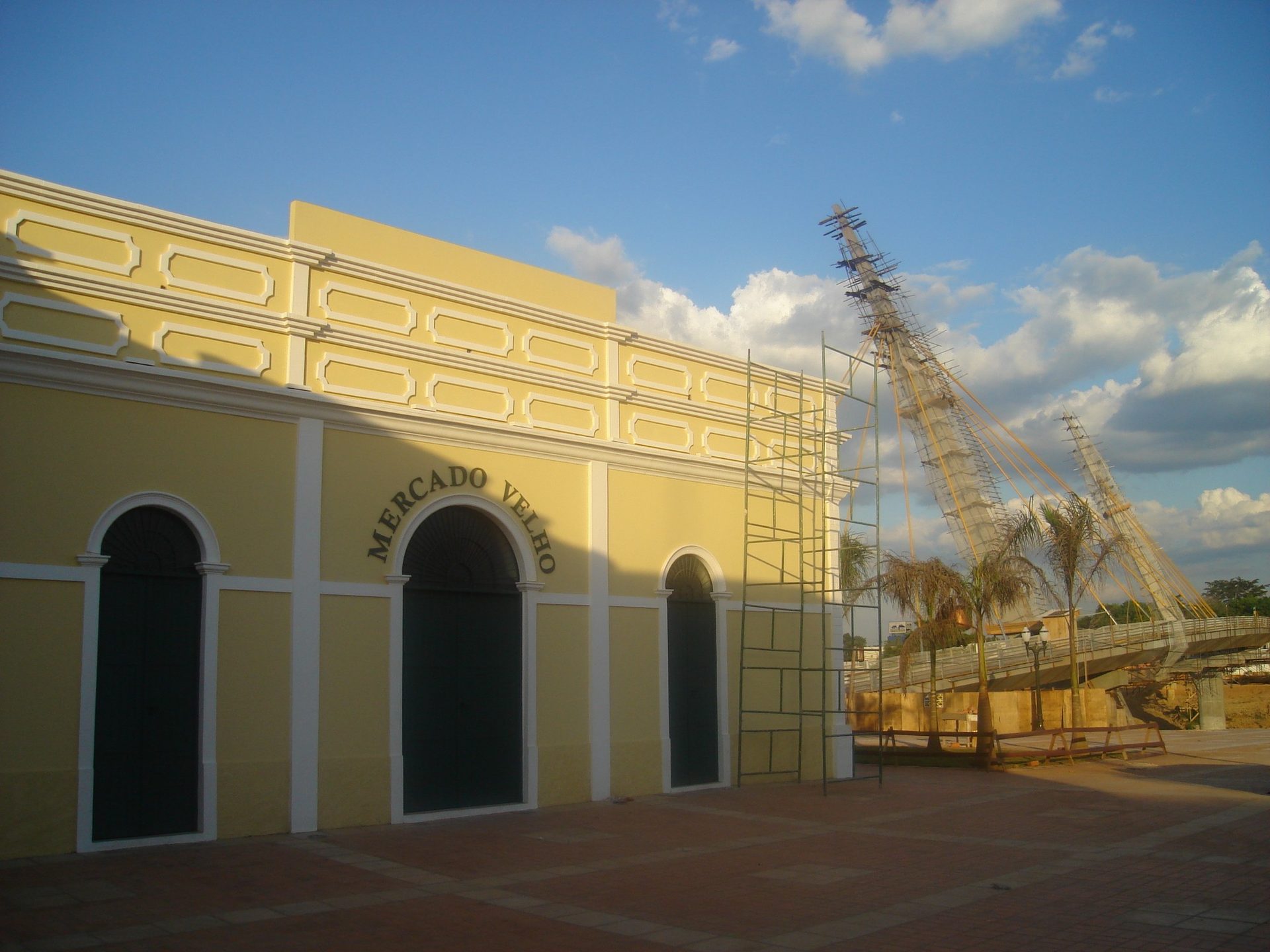 Mercado Velho de Rio Branco e a ponte sobre o Rio Acre, com o prédio amarelo à margem do rio no fim da tarde