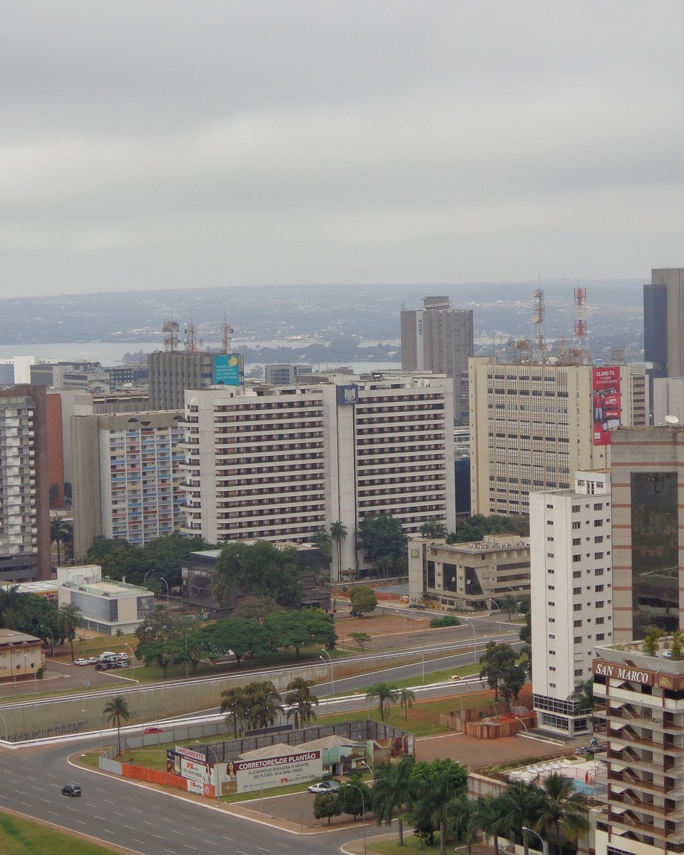 Vista do alto do Setor Comercial Sul e do Setor Bancário Sul, em Brasília, com os prédios de escritório em blocos alinhados, avenidas largas e o cerrado no horizonte.