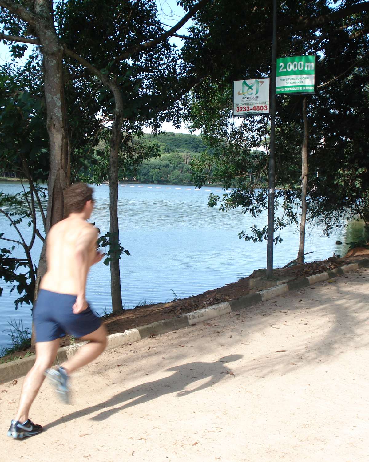 Homem correndo na pista de terra à beira da Lagoa do Taquaral, em Campinas, num dia de sol.