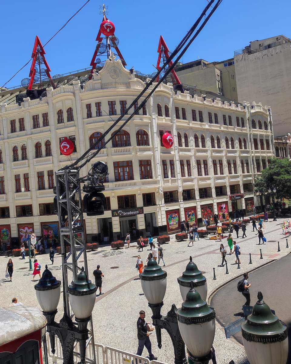 Pedestres na Rua XV de Novembro, no Centro de Curitiba, num dia de sol.