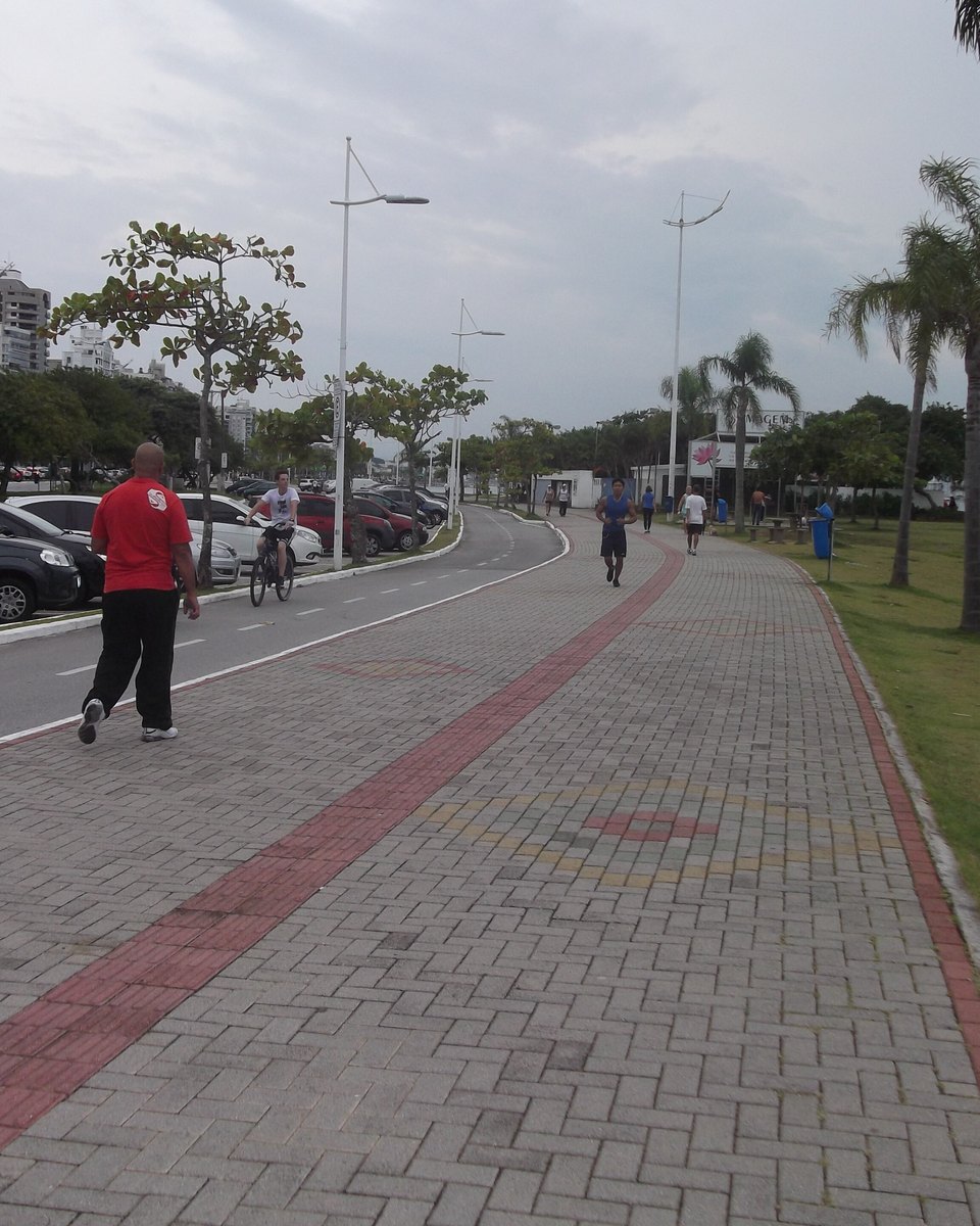 Calçadão da Avenida Beira-Mar Norte, em Florianópolis, com pedestres e ciclovia.