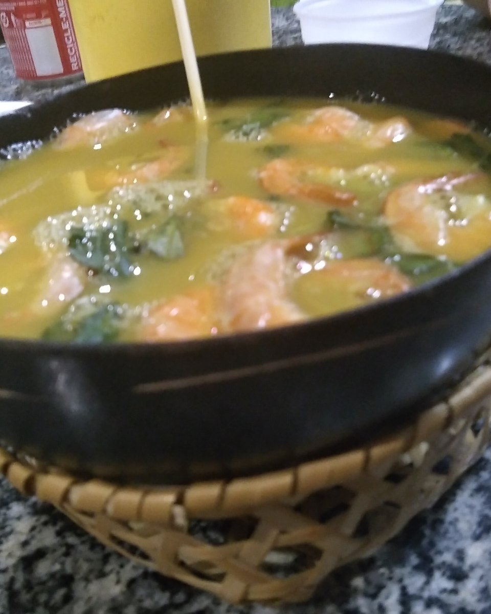 Tacacá servido na cuia, com caldo amarelo, camarão e folhas de jambu, sobre a mesa de um restaurante em Manaus.