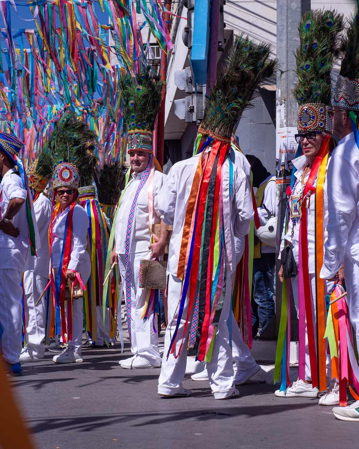Catopês de roupa branca, fitas coloridas e cocares de penas desfilando pela rua nas Festas de Agosto de Montes Claros, no Norte de Minas.