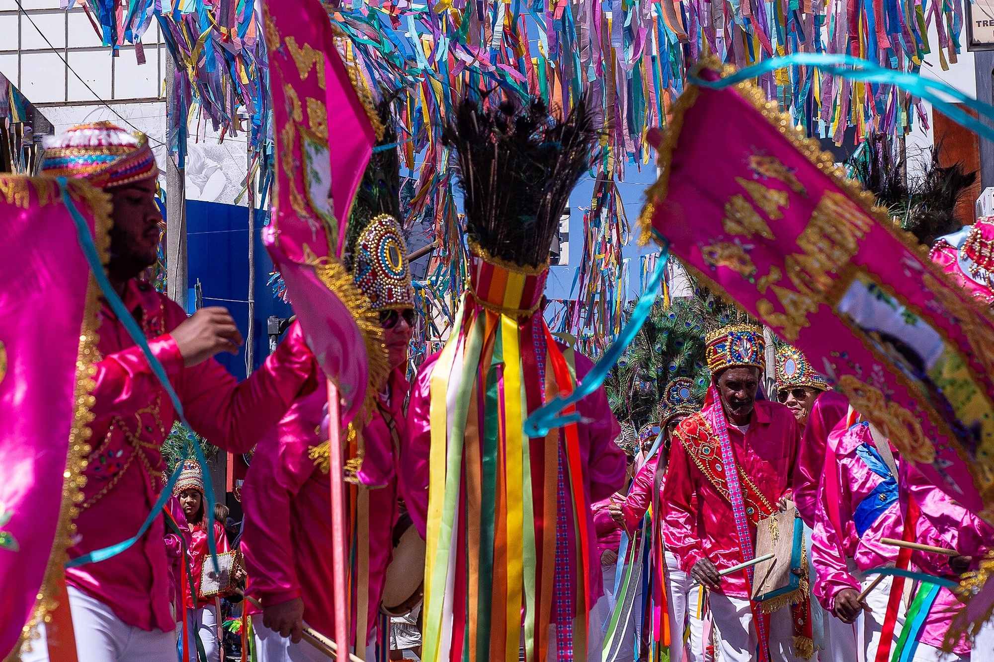 Catopês desfilando com estandartes e fitas coloridas nas Festas de Agosto de Montes Claros.