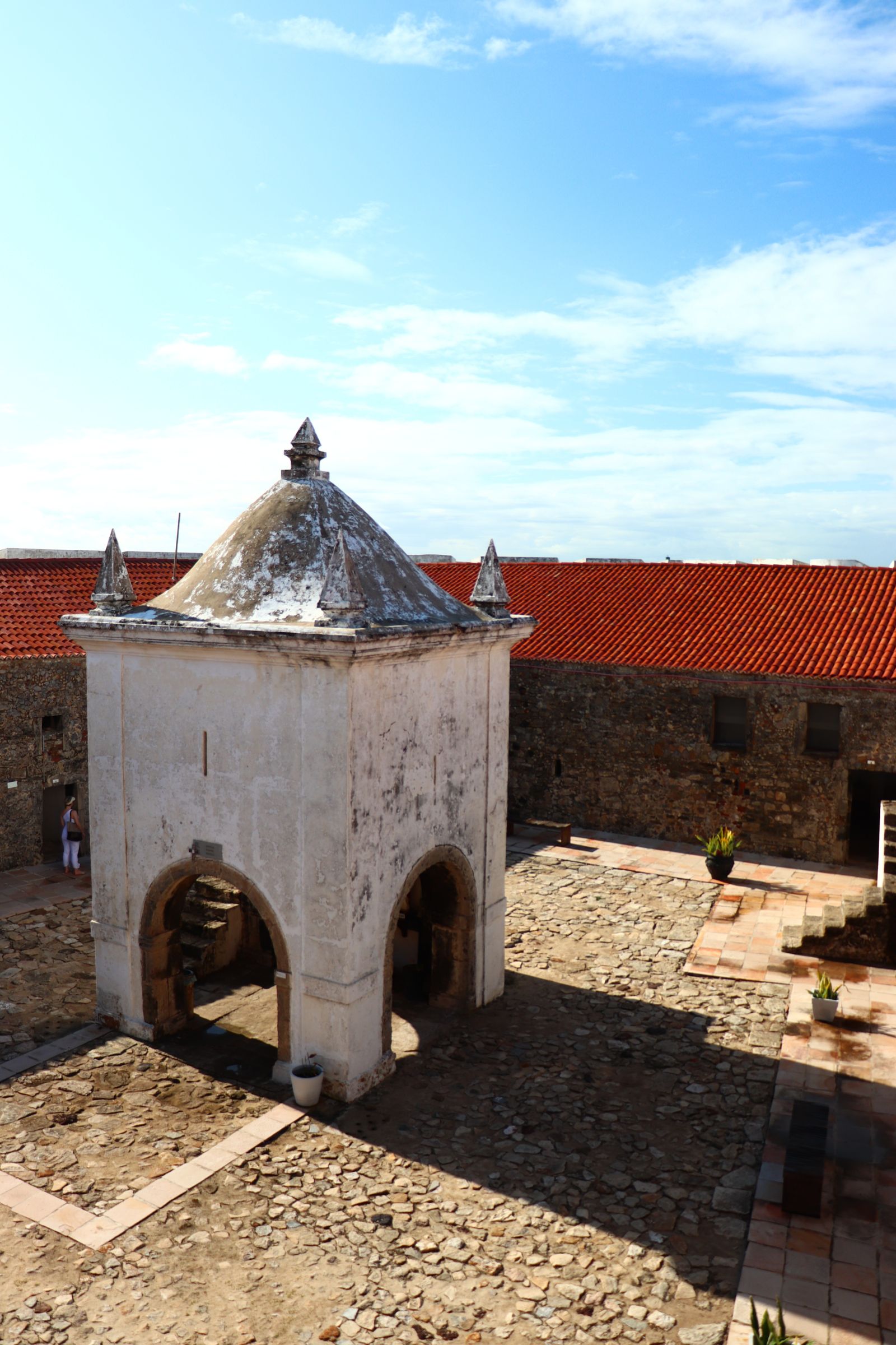 Pátio interno do Forte dos Reis Magos, com a capela em planta quadrada e telhado de quatro águas cercada por muros de pedra