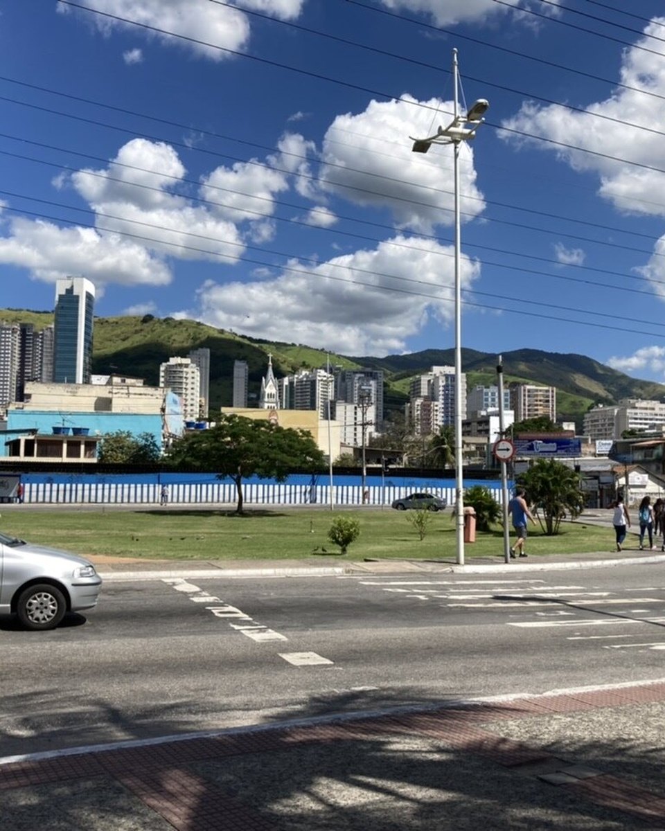 Via Light no Centro de Nova Iguaçu, com prédios e montanhas ao fundo.