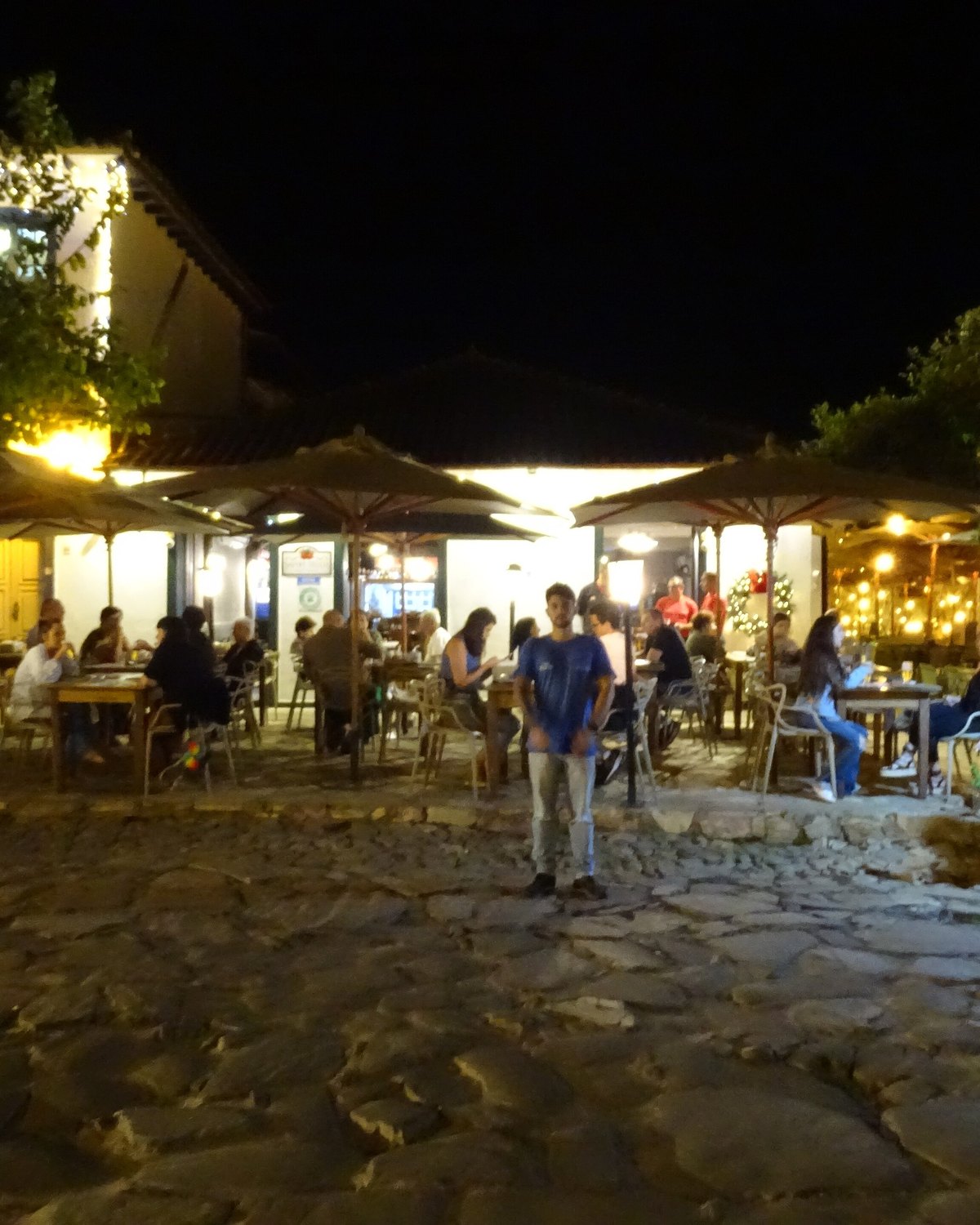 Mesas de restaurante cheias à noite no Largo das Forras, em Tiradentes.