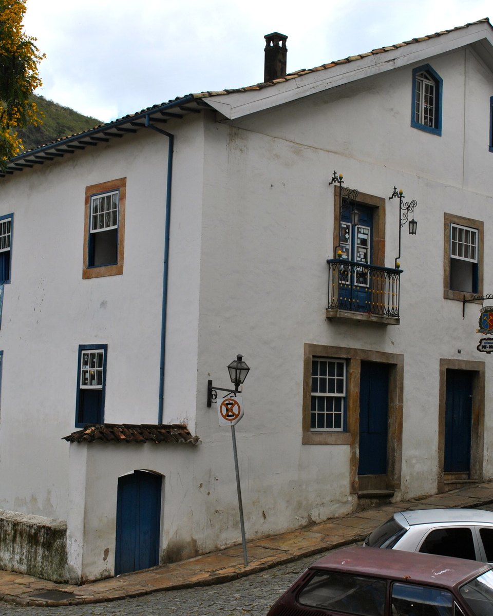 Casarão branco de dois andares de uma república estudantil numa esquina de Ouro Preto.