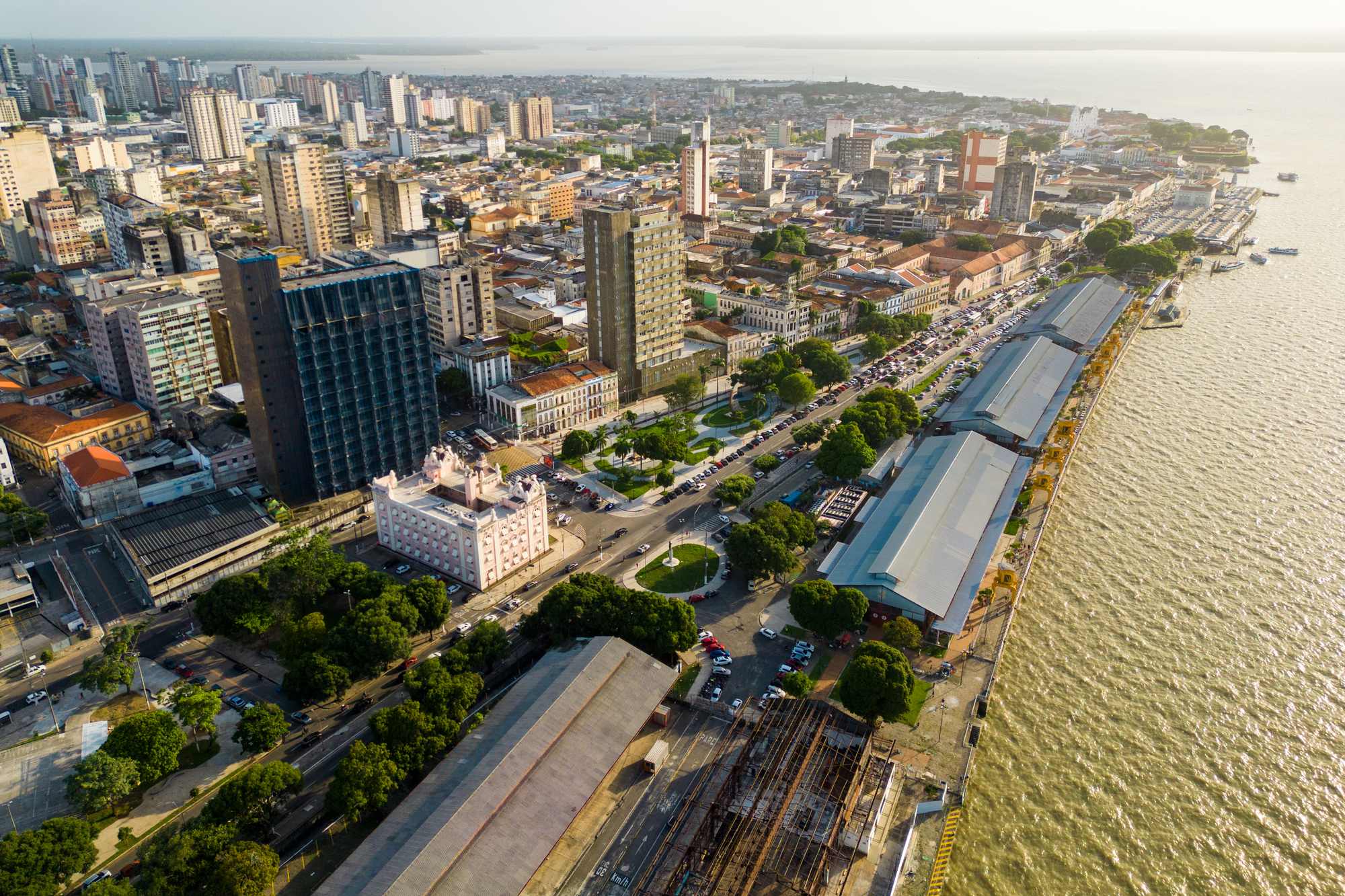 Vista aérea da orla de Belém na baía do Guajará, com os galpões do Ver-o-Peso e da Estação das Docas, o Palacete Bolonha e os prédios do centro.