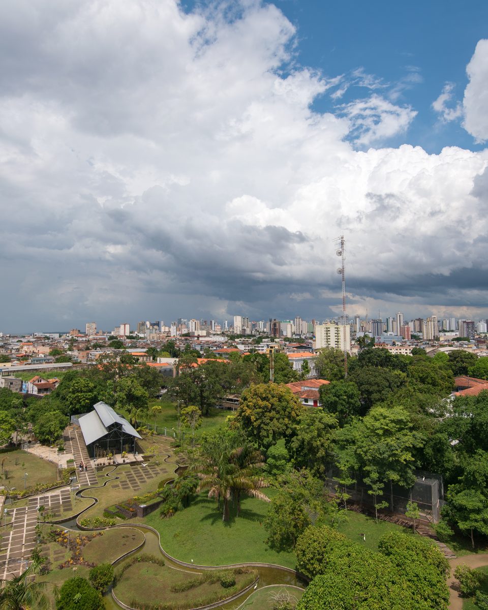 Mangal das Garças visto do alto, com os espelhos d'água, os caminhos do parque e os prédios de Belém ao fundo.