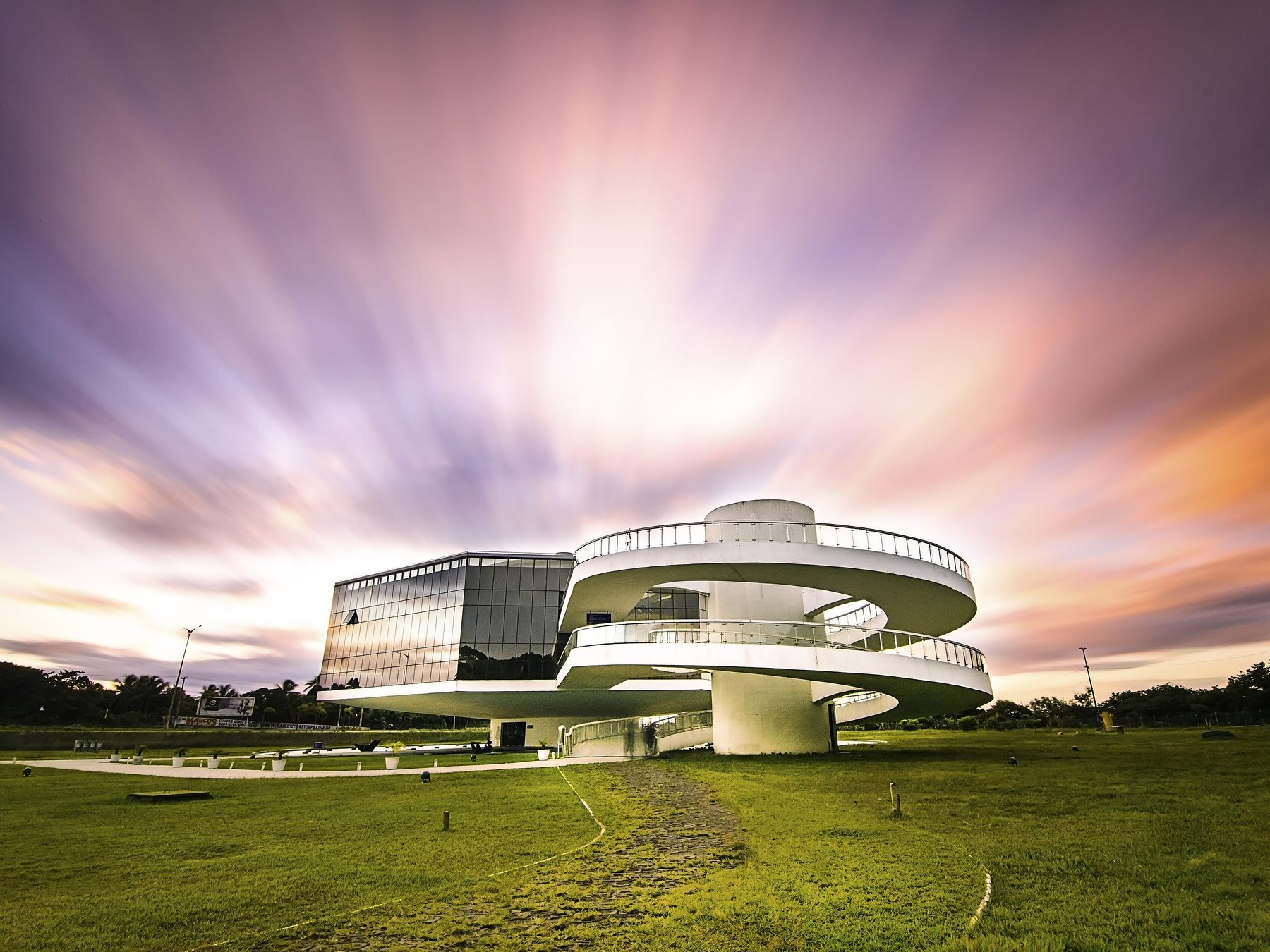 Estação Cabo Branco, projetada por Oscar Niemeyer em João Pessoa, com a rampa curva de concreto branco e o céu alaranjado do fim de tarde atrás