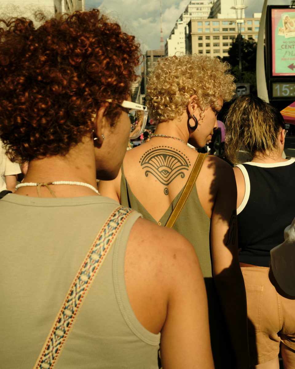 Grupo de pessoas com roupas de verão na Avenida Paulista, em São Paulo.