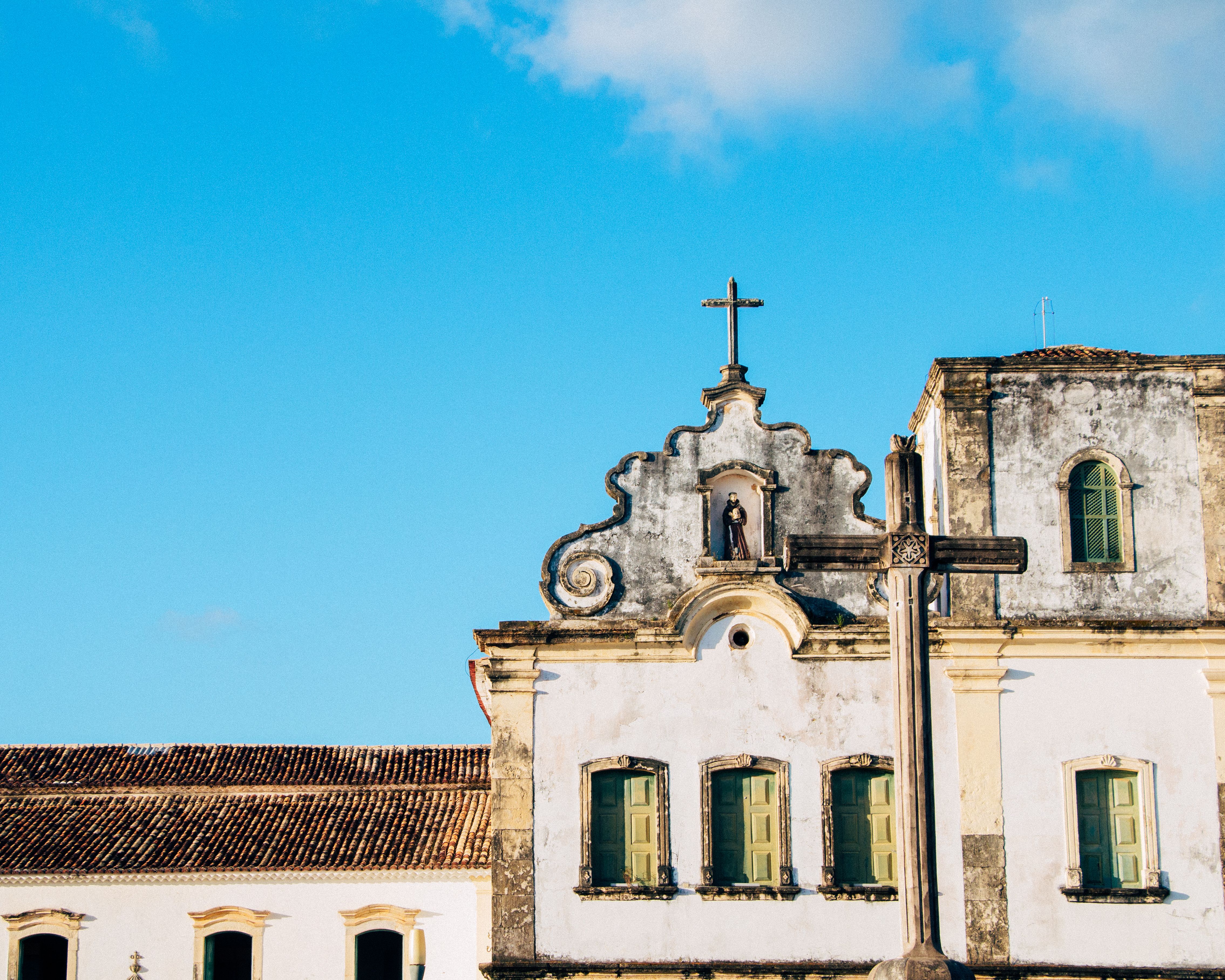 Fachada histórica de igreja colonial no centro de São Cristóvão, com torre e cantaria de pedra sob céu azul